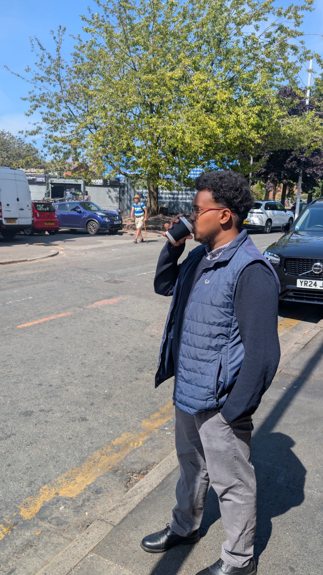 Abdi Ahmed drinking coffee on a Princes Park street