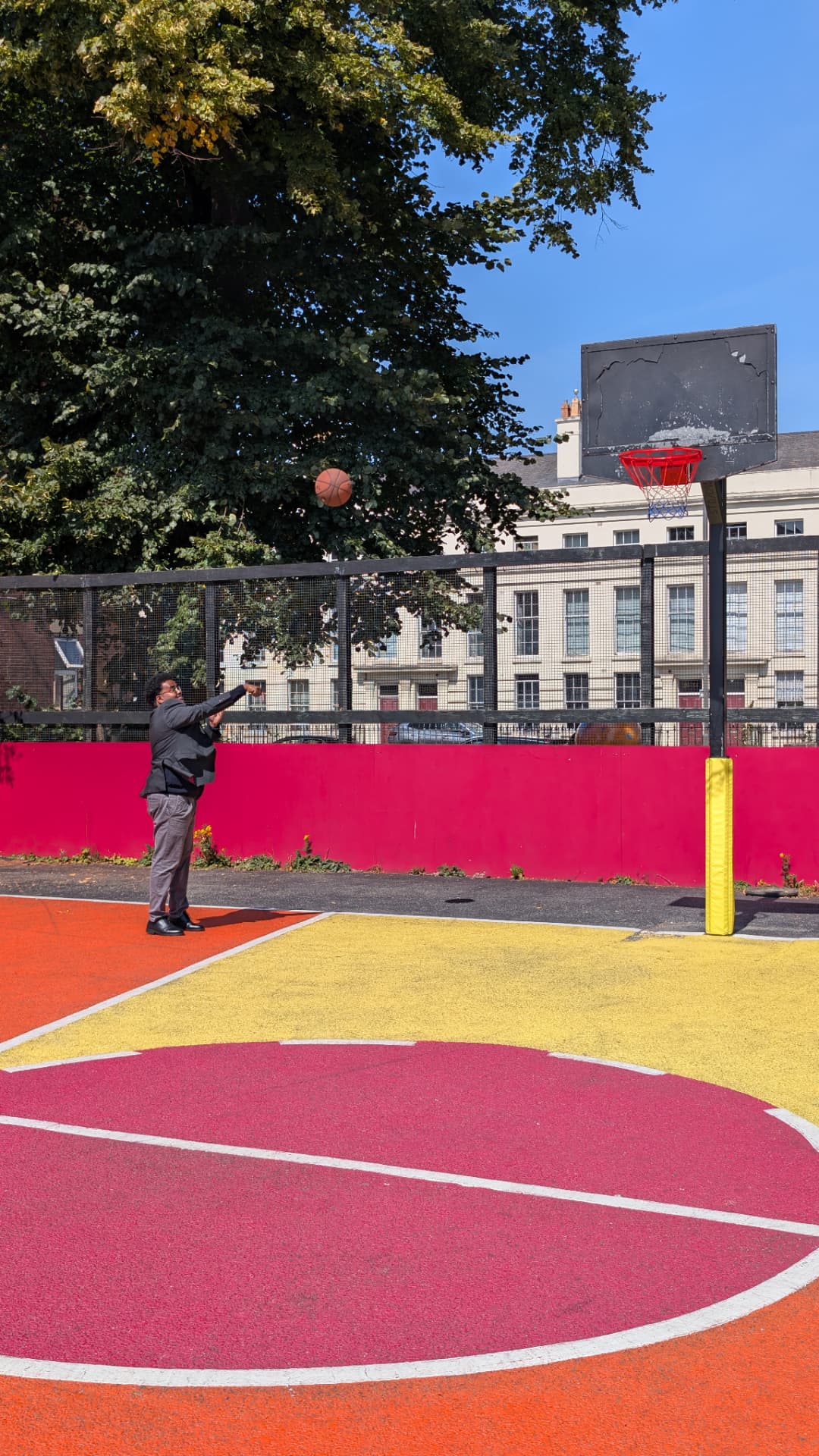 Abdi Ahmed shooting a basketball on an outdoor court in Liverpool